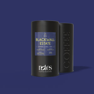 Two black cylindrical containers filled with 100% home compostable, Nespresso® compatible coffee pods with 'Blackwall Estate' label on a purple background.